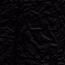 a crumpled piece of black paper with a white cross in the middle