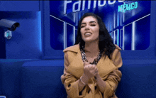 a woman in a yellow coat is sitting in front of a mexico sign