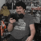 a man wearing a shirt that says minch is holding a tablet