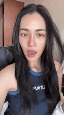 a woman wearing a blue tank top with mari written on it
