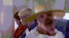 a man in a cowboy hat is sitting next to another man in a white shirt on a plane .