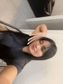 a woman with long black hair is taking a selfie