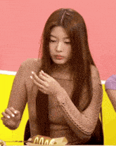 a woman sitting at a table with a mcdonalds hot dog in front of her