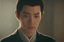 a close up of a young man 's face with a very serious look on his face .