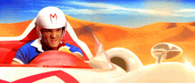 a man wearing a helmet with the letter m on it is driving a race car