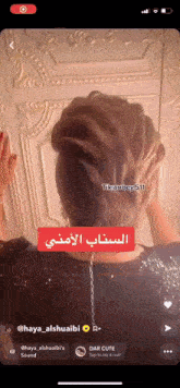 a woman 's hair is being shown on a phone screen with arabic writing