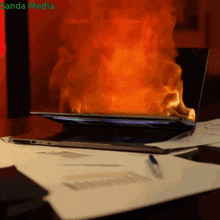 a laptop that is on fire with the words sanda media written on the bottom
