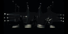 a man is playing a guitar in a dark room .