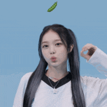 a girl with pigtails is blowing a kiss with a peas in the air