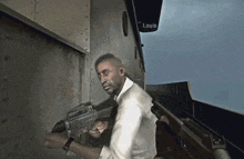 a man is holding a gun in front of a louis sign