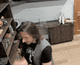 a man wearing a black shirt that says pirate is standing in front of a shelf