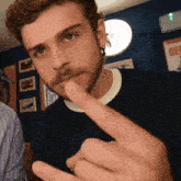 a man with a beard is making a gesture with his middle finger