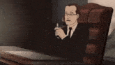 a man in a suit and tie is sitting at a desk holding a lighter in his hand .