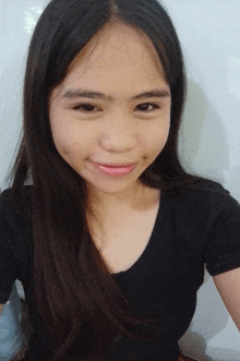a girl with long hair is smiling for the camera