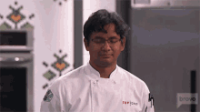 a man in a chef 's uniform with the word top on it