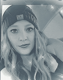 a woman wearing a black beanie with a cc logo on it