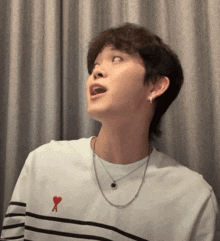 a young man wearing a striped shirt with a red heart on the chest