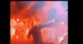 a blurry picture of a man playing a guitar in front of a crowd