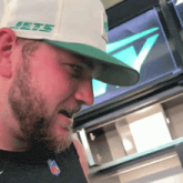 a man with a beard wears a hat that says jets on it