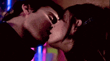 a man and a woman are kissing in the dark