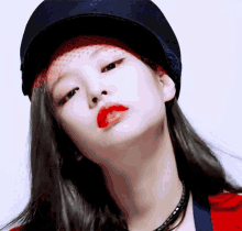 a close up of a woman wearing a hat and red lipstick .