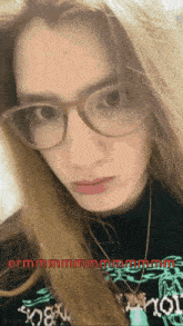 a woman wearing glasses and a shirt that says ' sn8m ' on it