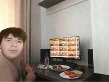 a man sitting in front of a burger king computer monitor