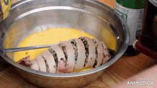 a squid is being cooked in a metal bowl that says made in animotica on the bottom