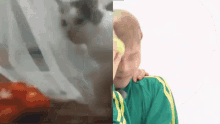 a man in a green shirt is holding another man 's arm