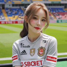a girl wearing a soccer jersey with adidas and sbobet on the side