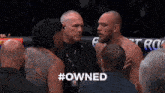a group of men are standing in a boxing ring and one of them has the word #owned on his back