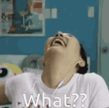 a woman wearing headphones is laughing and asking what .