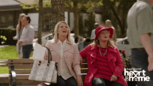 two women sit on a bench with the words heart & frame on the bottom right