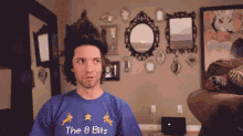 a man wearing a blue shirt that says the 8 bits on it