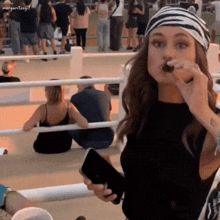 a woman with a bandana on her head is eating a candy bar