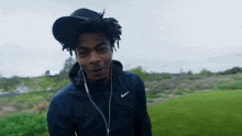 a man wearing ear buds and a nike jacket