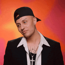 a man wearing a hat and a necklace with a cross