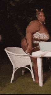 a woman in a bikini is standing in front of a table