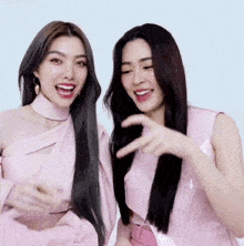 two women are standing next to each other and smiling .