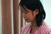 a woman in a striped shirt is crying