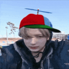 a young man wearing a hat with a propeller on it .