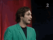 two men are standing in front of a red curtain with the number 2 on the bottom right corner