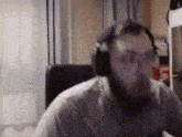 a man with a beard wearing headphones and glasses