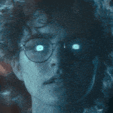 a close up of a woman 's face with glasses and glowing eyes