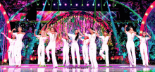 a group of women standing on a stage with their arms in the air