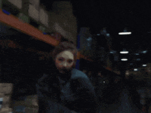 two women are dancing in a dark warehouse with boxes and a yellow ladder