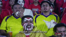 a man in a yellow shirt says kita patah patahkan kaki diorang