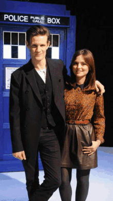 a man and a woman are posing in front of a police public call box