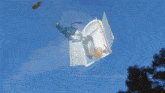 clothes are flying in the air in front of a house with a blue sky in the background
