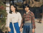 two women are holding hands and one of them is making a face